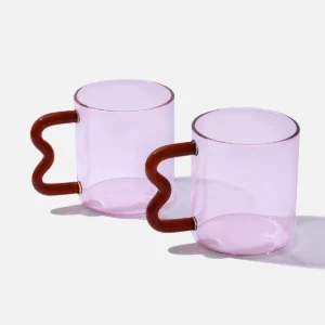 Pink glass mug with a red wavy handle, modern handcrafted design