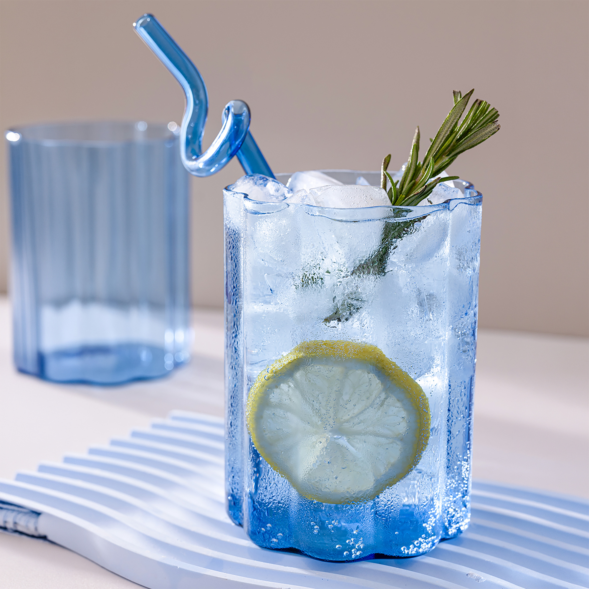 Close-up of condensation and ripple texture on a Blue Ripple Glass with lemon and ice.